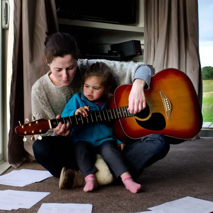 Mother plays guitar with her daughter