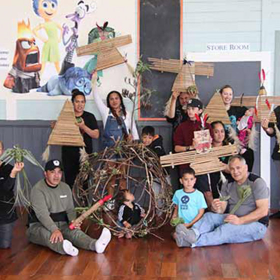 Group of adults and tamariki showing their artistic creations. 