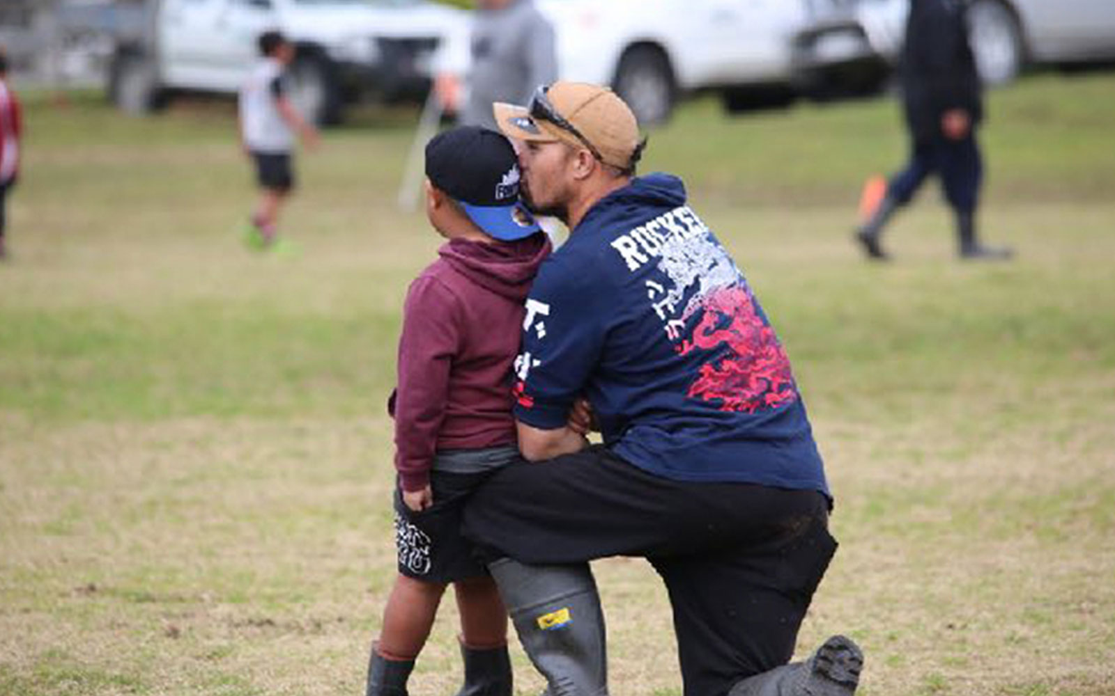 Father and son at rugby game in Ūawa