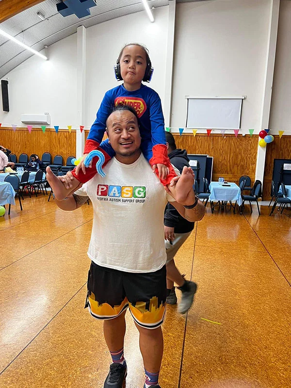Daniel Filemoni carries his son on his shoulders.